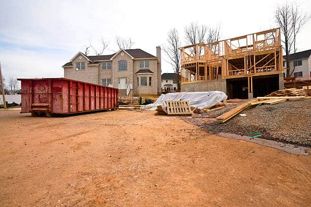 Préparation du chantier de rénovation d'une maison avec l'installation d'une benne pour les déchets