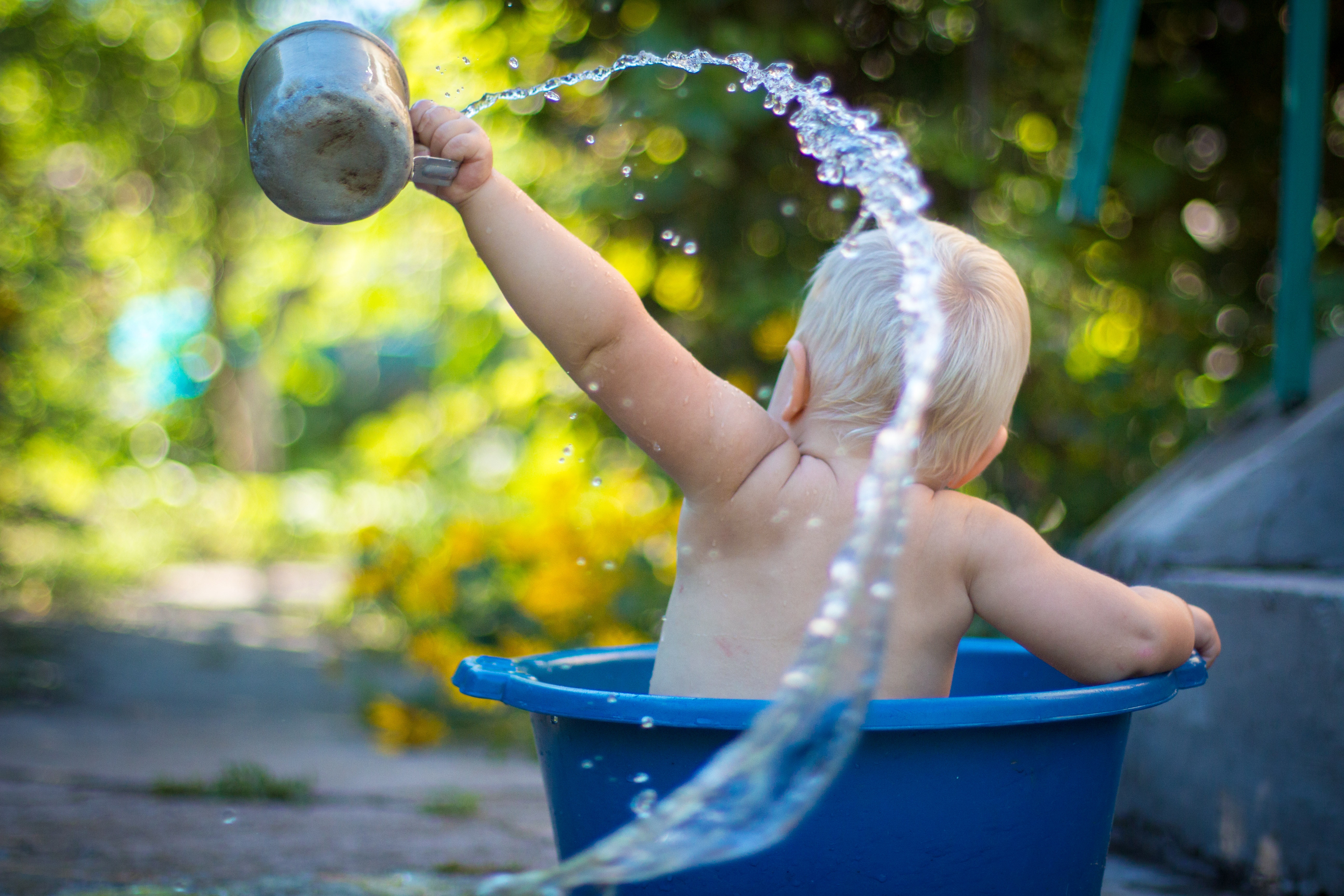 Enfant jouant dehors dans un bac d'eau