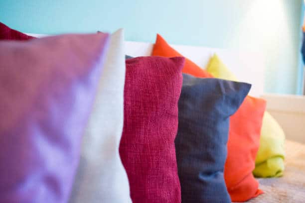 Plusieurs coussins de couleurs sur un lit