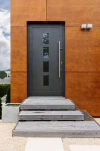 Devant d'une maison avec petit escalier et porte en alu