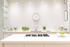 Cuisine blanche et propre avec horloge et plantes autour de l'évier