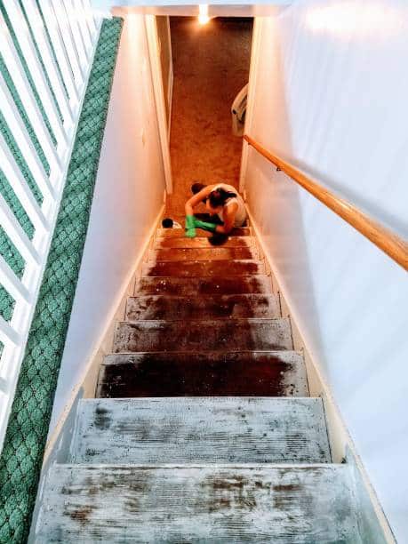 Personne en train de décaper un vieil escalier en bois