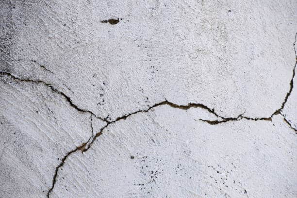 Gros plan sur la façade fissurée d'une vieille maison